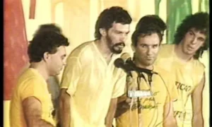 Sócrates e Casagrande com camisas amarelas no palanque do comício das Diretas Já em 1984